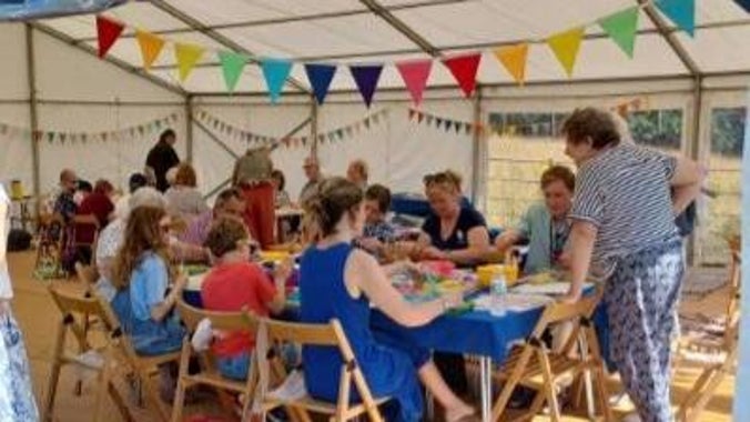 A volunteer leads a wet felting workshop in our festival marquee, while a bookbinding workshop takes place in the background